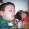 A boy and a boxer asleep together.