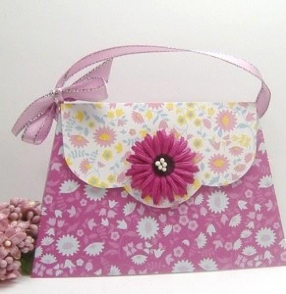 A handmade pink card that resembles a purse.