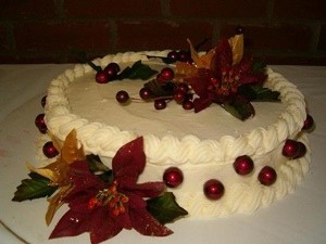 White frosted cake decorated with poinsettias.