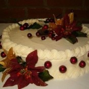 White frosted cake decorated with poinsettias.