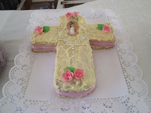 A cake shaped like a cross to celebrate First Communion.