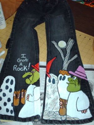 A pair of jeans painted with a Halloween scene from Charlie Brown.