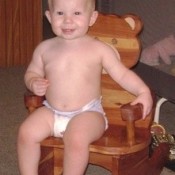 Toddler sitting on rocking chair.