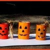 A collection recycled cans decorated to resemble jack-'o-lanterns.
