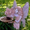 A garden fairy holding a shallow bowl.