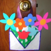 brightly colored paper flowers in decorated envelop basket