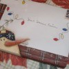A Christmas card envelope with hand drawn snowman and string of lights.