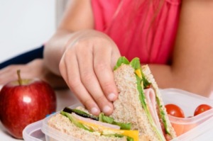 A girl eating packed lunch at school.