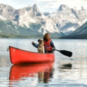 A woman paddling a canoe alone.