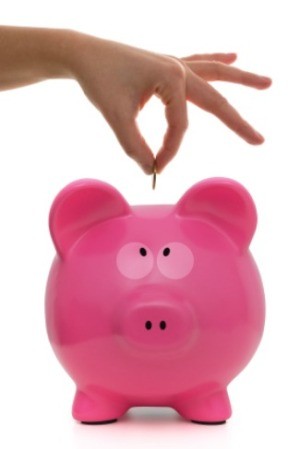 putting a penny into a pink piggy bank