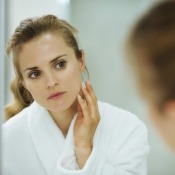 woman looking at her skin