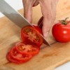 Cutting tomatoes on a cutting board.