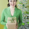 A woman holding a gift wrapped in recycled paper.