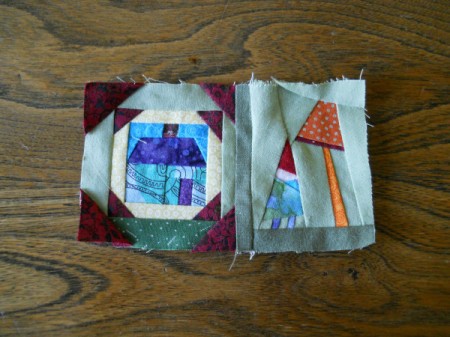 Closeup of log cabin style house mini block and garden gnome with mushroom.