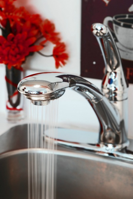 Faucet running in a kitchen that uses well water.