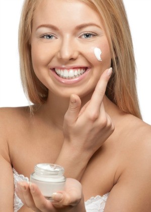 Woman putting on eye cream.
