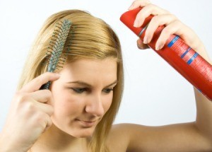 Girl putting on hairspray.