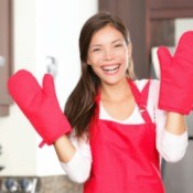 Woman wearing oven mitts.