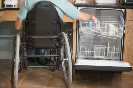 Man in Wheelchair Washing Dishes