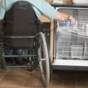 Man in Wheelchair Washing Dishes