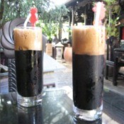 Two tall glasses of iced Vietnamese coffee.