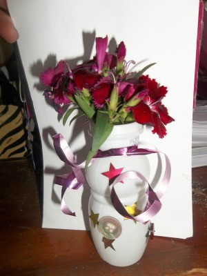 A mini flower vase made from a recycled container.