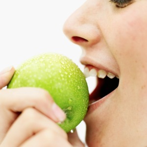 A woman eating an apple.