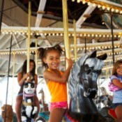 A girl on a merry go round at an amusement park.