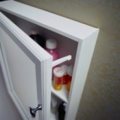 A medicine cabinet door with a child lock on it to help it stayed closed.