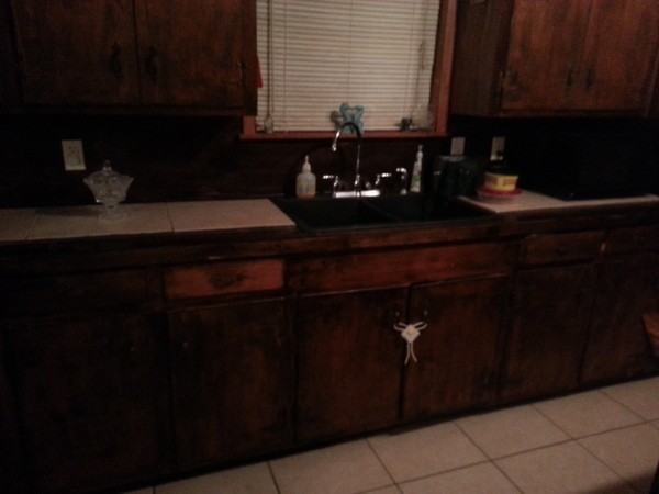 Dark brown cabinets in dated kitchen.