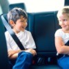 Two kids playing a game on a road trip.