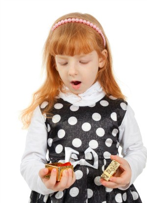 A girl opening a small gift.