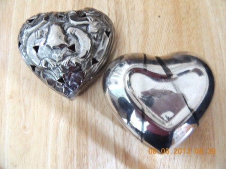 Heart shaped silver bowl and lid with a dark line from rubber band.