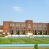 Photo of a large high school and its football field.