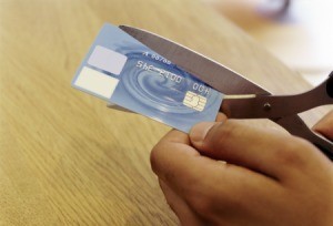 Cutting a credit card with scissors.