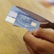 Cutting a credit card with scissors.