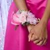 A sweet pink corsage worn by a girl in a pink dress.