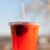 An insulated cup with a reusable plastic drinking straw.