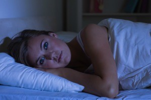 A woman laying awake at night.