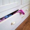 A chest of drawers with clothing in them.