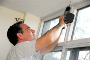A man installing window shades.