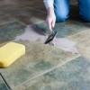 A handyman replacing floor grout.