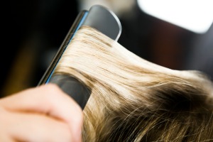 Using a flat iron on hair.