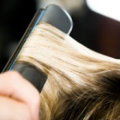 Using a flat iron on hair.