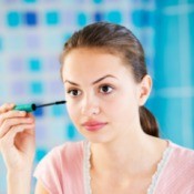 A teen girl putting on makeup.