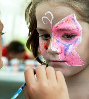 A girl having her face painted.