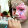 A girl having her face painted.