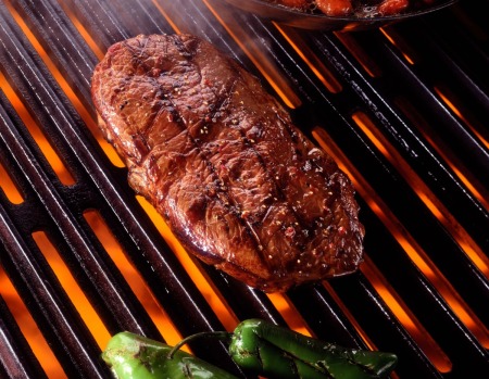 Tender rib eye steak on a grill.