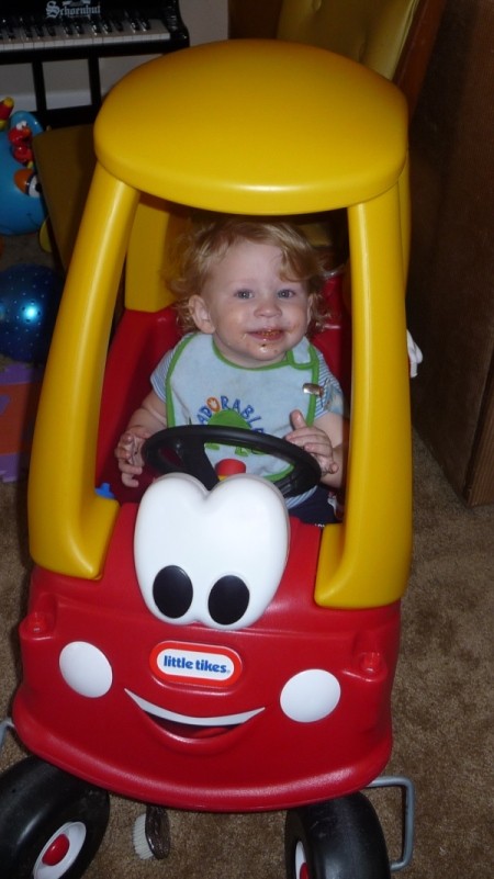 Toddler in red and yellow Little Tikes car.