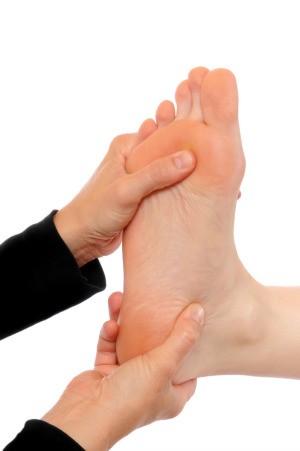 Using acupressure on a foot.